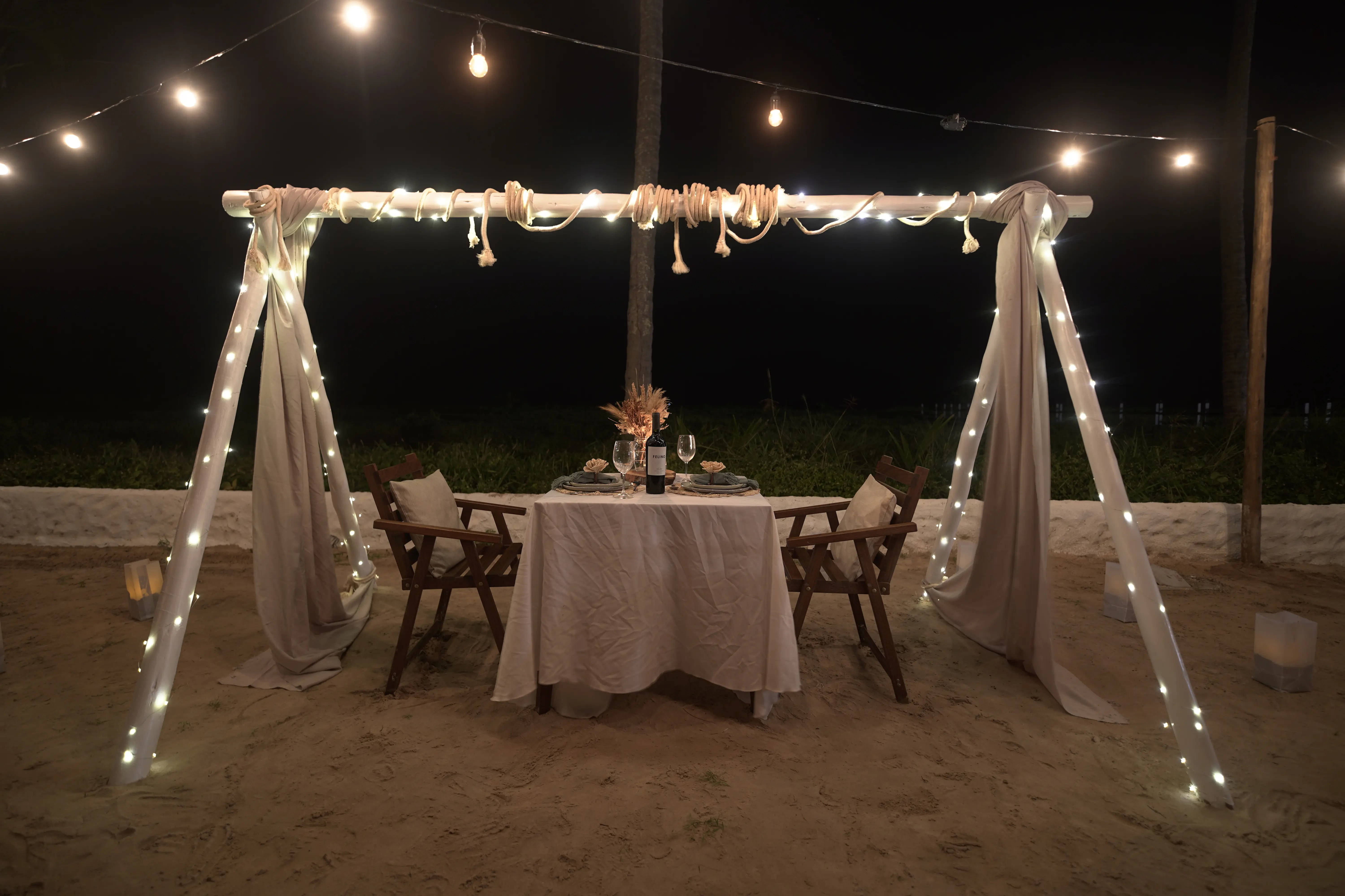 Cabana iluminada à luz de velas no Vivari Beach Club durante a noite