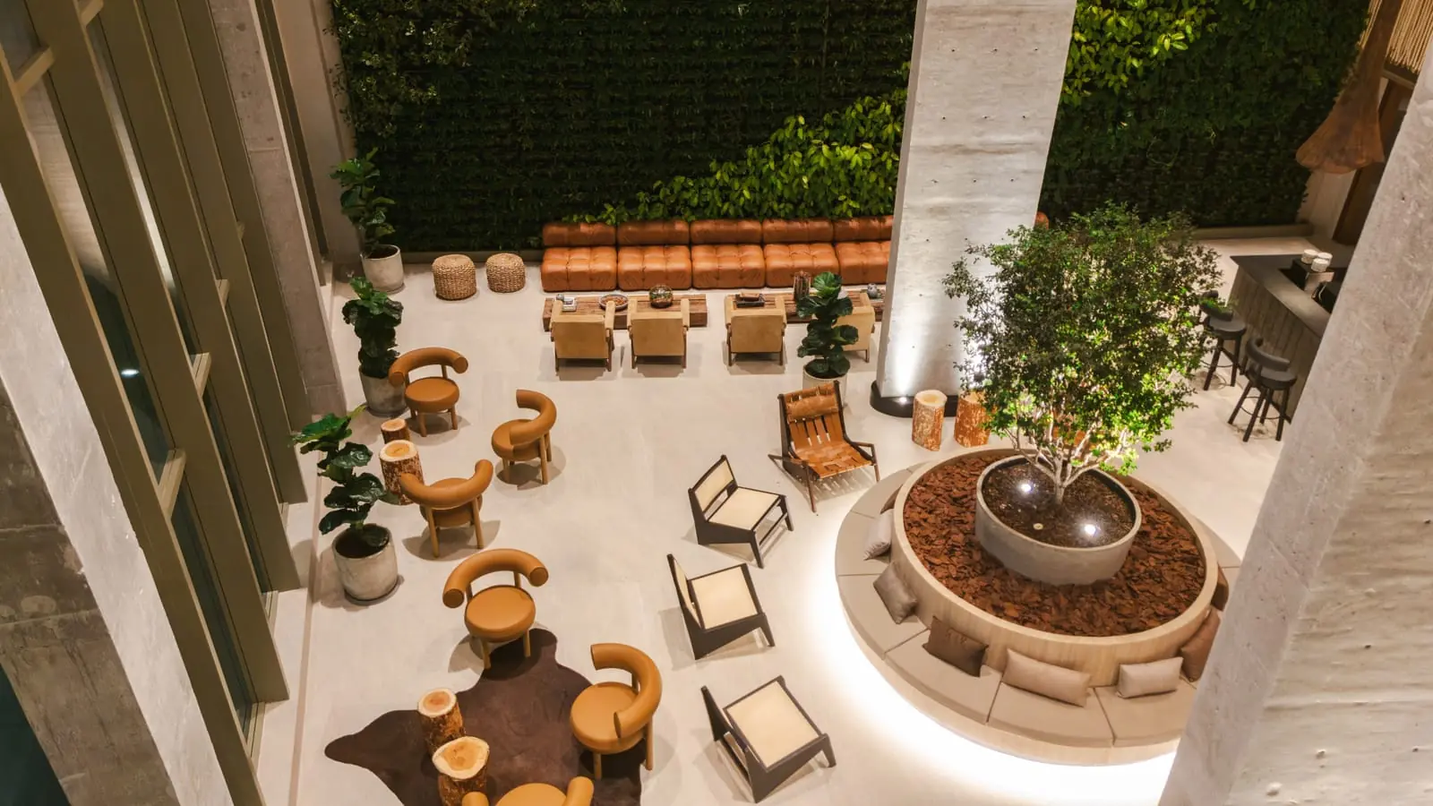 Vista aérea das poltronas do lobby, entre plantas e árvores