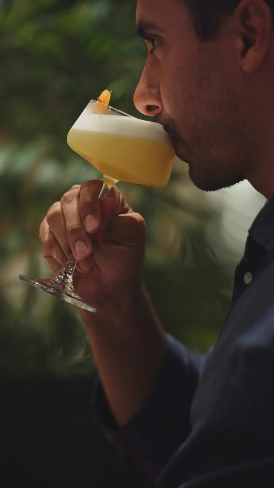 Hóspede apreciando um drink no bar do lobby do Sais Beach Living